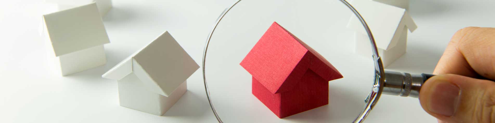 magnifying glass over red wooden house